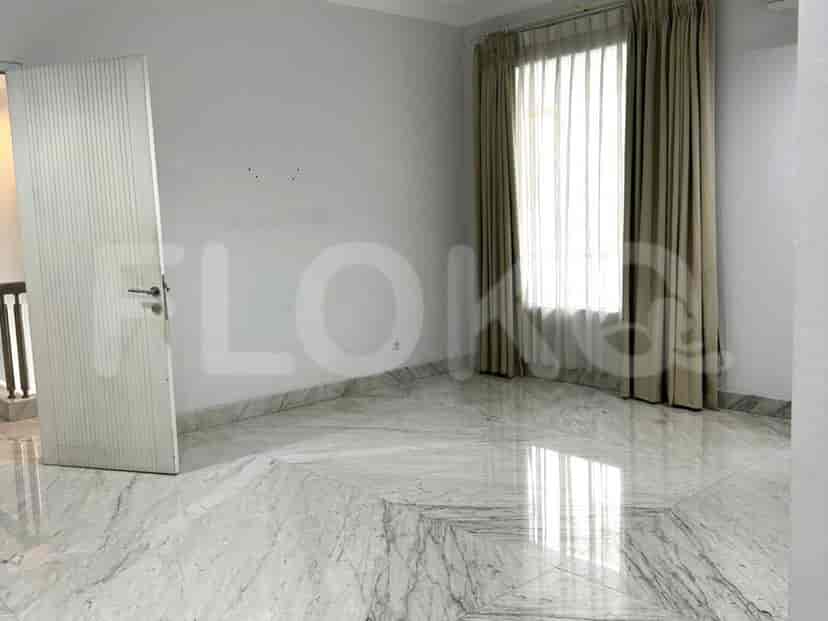 A bedroom with marble flooring, neutral-colored curtains, and built-in closets.