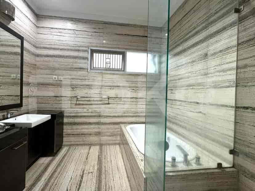 A luxury bathroom featuring a standalone bathtub, marble walls, and a glass shower enclosure.