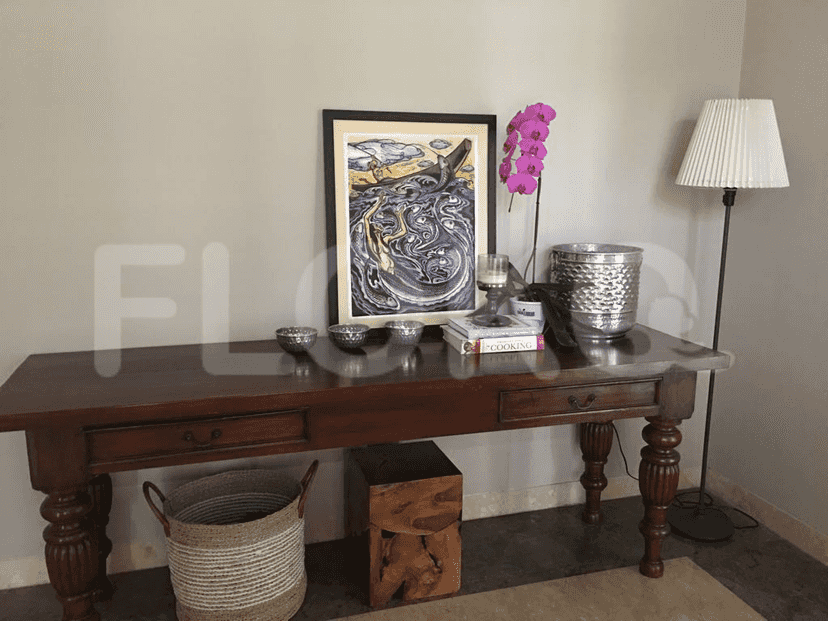 A living room with a wooden table, a floor lamp, and decorative items.