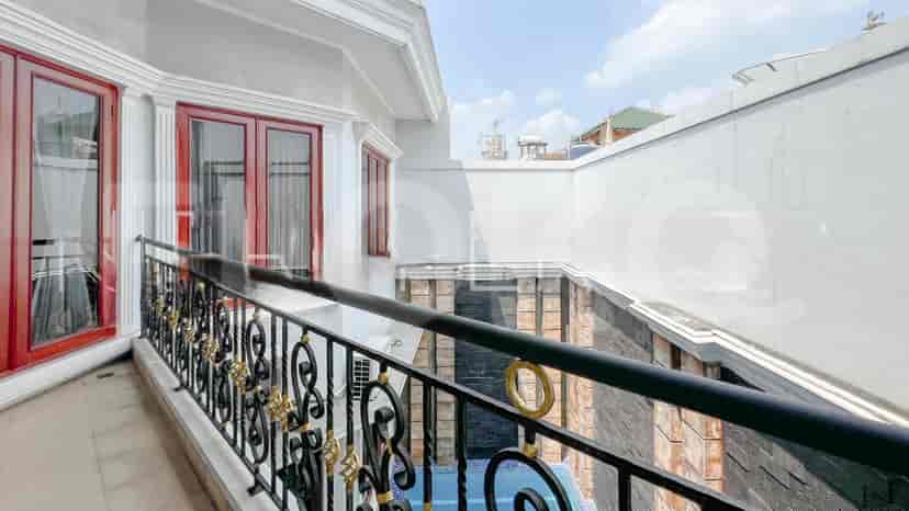 A balcony with a wrought iron railing offering views of the surroundings.