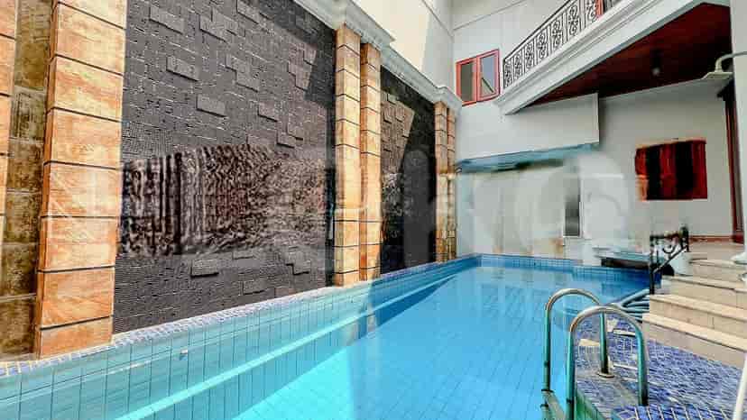 An outdoor pool area with a swimming pool, water feature, and seating area.