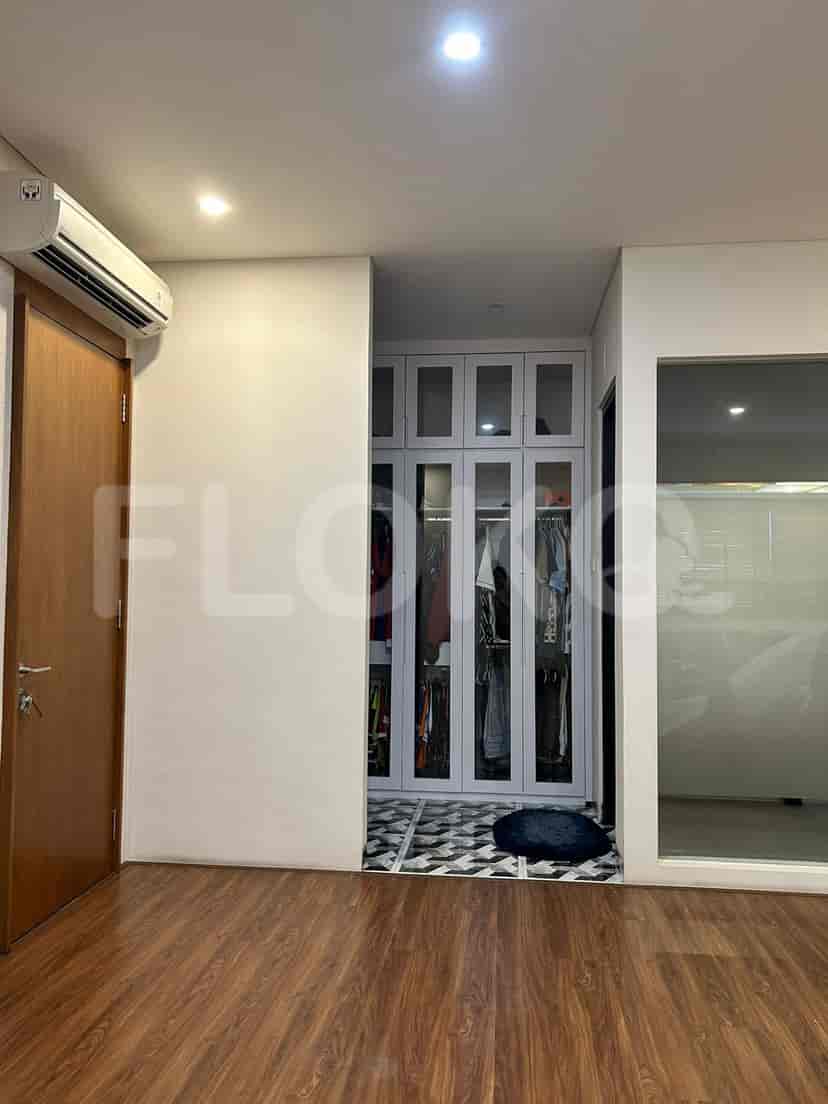 A walk-in closet with mirrored doors and interior storage.