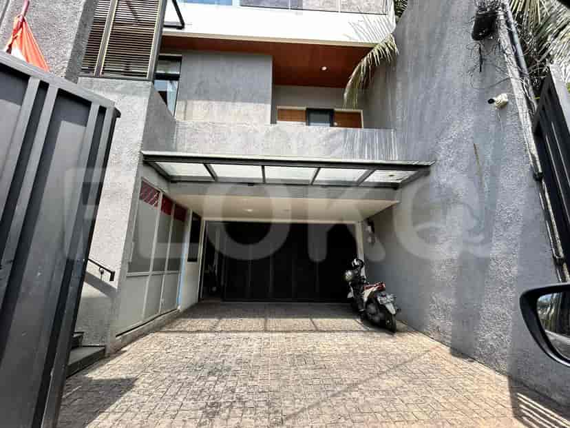 A view of the property showing the garage with a motorcycle parked inside, and a partial view of the house's facade.