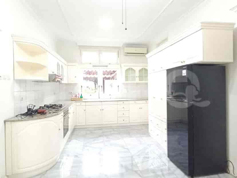 A white kitchen with light-colored cabinets, a gas stove, and marble countertops.