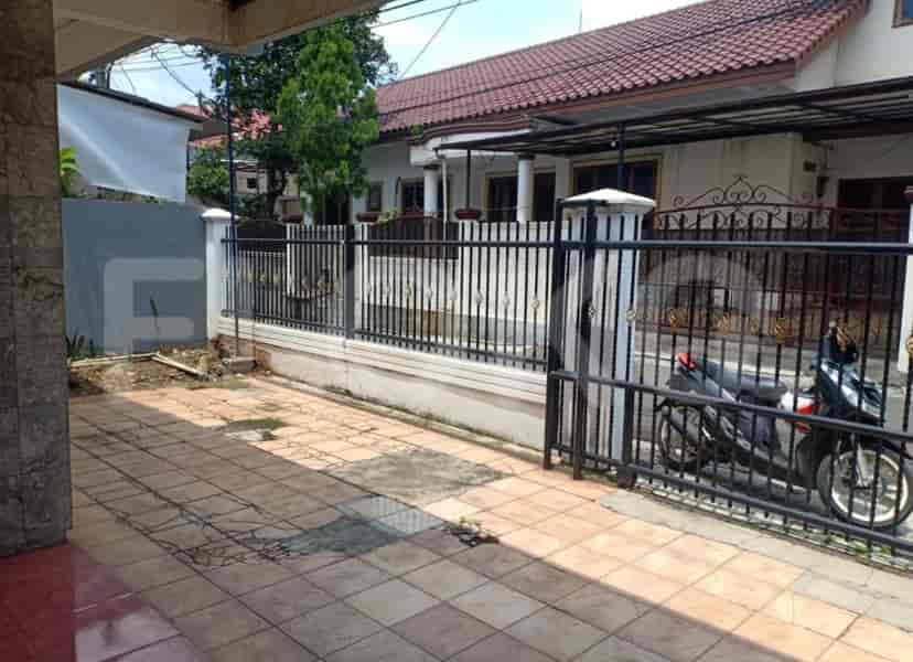 Exterior view of a house with a tiled driveway, black gate, and parked motorcycle.