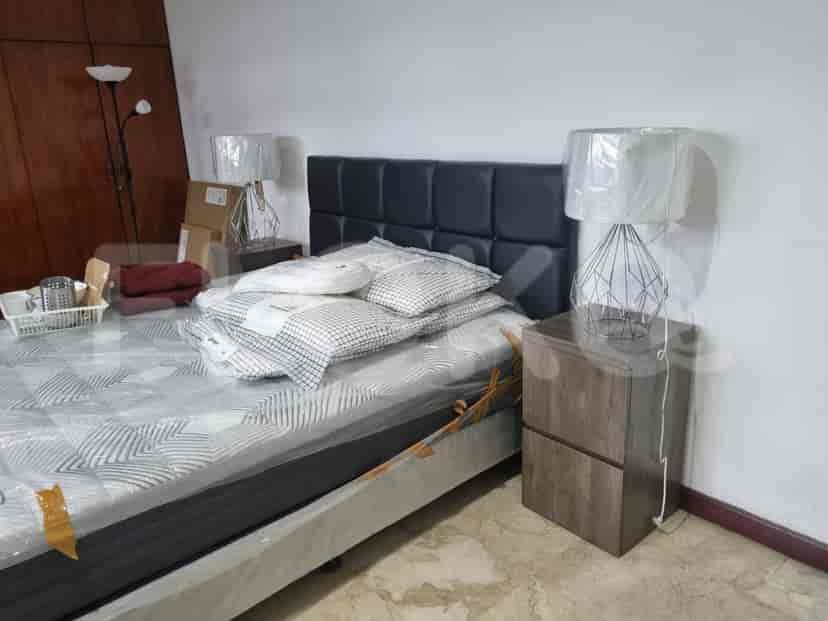 A bedroom with a bed, nightstands, and decorative lamps.