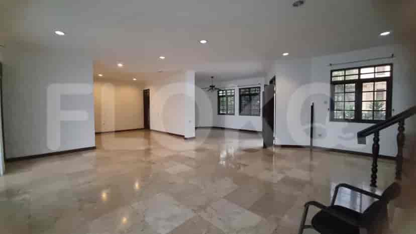 A large living room with marble flooring, recessed lighting, and windows offering a view.