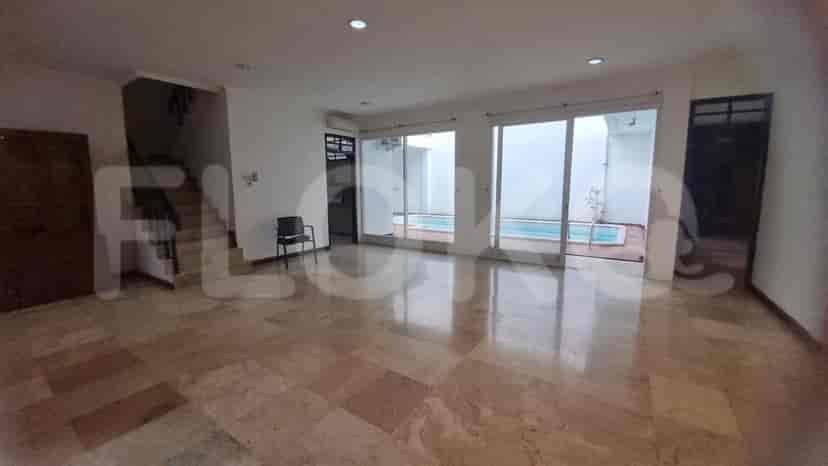 Living area with marble flooring and sliding glass doors leading to the swimming pool.
