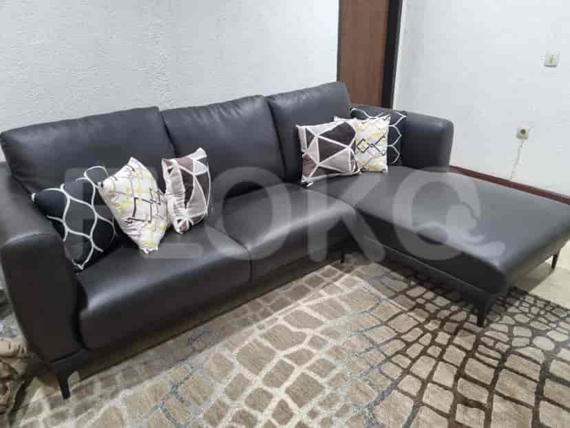 A living room with a sectional sofa, a patterned rug, and a coffee table.