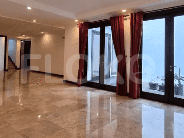 A spacious living room with marble flooring, large windows with red curtains, and access to an outdoor area.