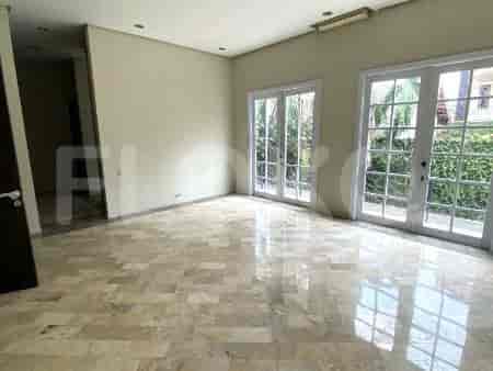 Ruang tamu dengan dua set pintu Prancis, lantai marmer, dan dinding krem.
