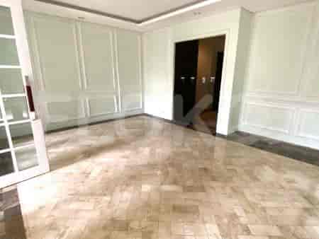 Ruang tamu dengan panel dinding dekoratif, lantai marmer, dan pintu yang mengarah ke ruangan lain.