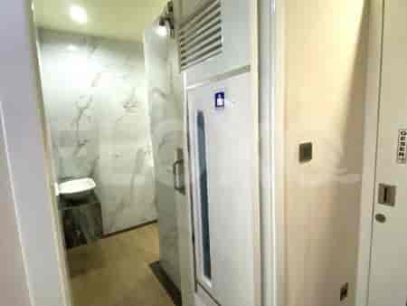 Area kamar mandi atau toilet kecil yang menampilkan desain modern, wastafel, dan dinding cermin.
