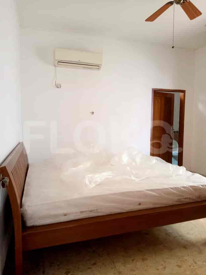 A bedroom with a wooden bed, air conditioning unit and a door