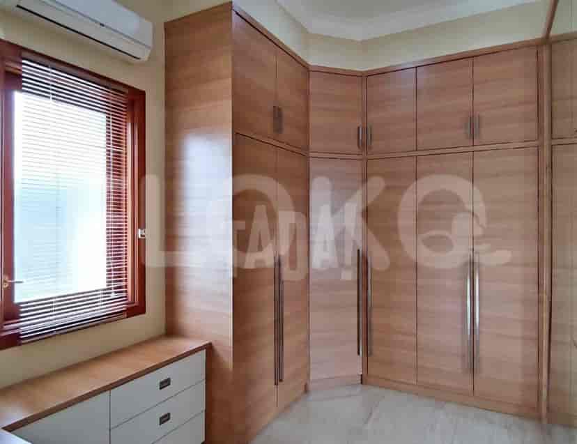 A walk-in closet featuring light wood cabinetry and ample storage.