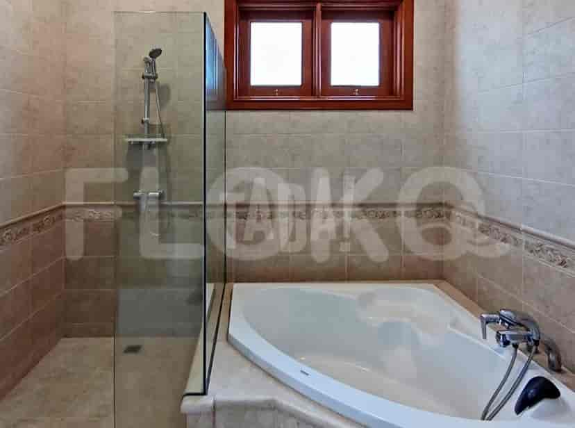 A modern bathroom with a bathtub, shower, and tile surround.