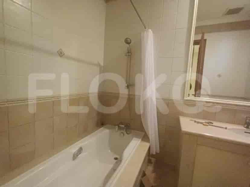 A bathroom with a bathtub, shower, and tile surround.