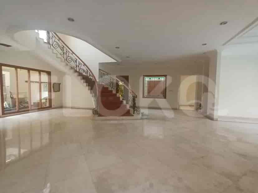 Another view of the living room with a staircase and large windows.