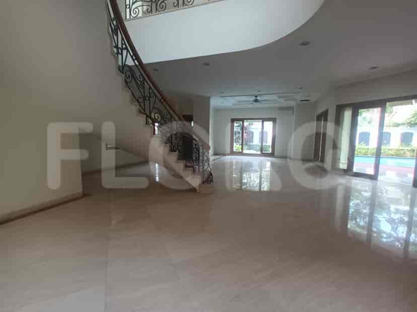 A living room with a spiral staircase, large windows, and a view of the pool.