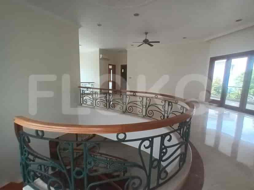 A landing area with a curved staircase and views into the living area.