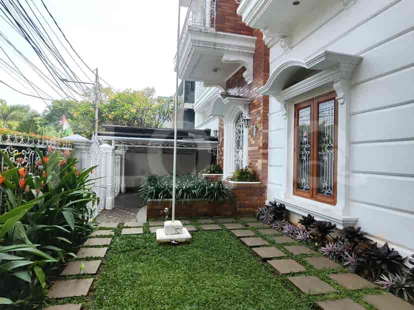 Exterior view of a house with a well-maintained lawn, brick facade, and white accents.