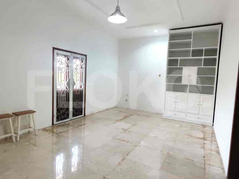 A minimalist room featuring a door with an ornate design and a ceiling light.