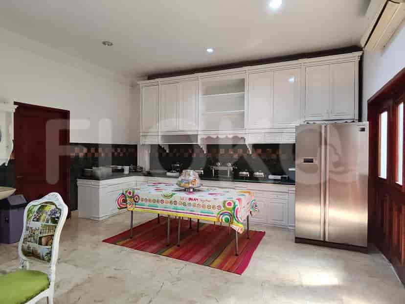 A kitchen with white cabinets, stainless steel appliances, and a dining table.
