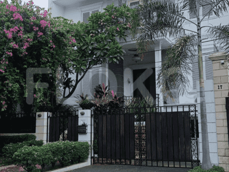 A two-story house with a gated entrance, lush landscaping, and a number 17 address.
