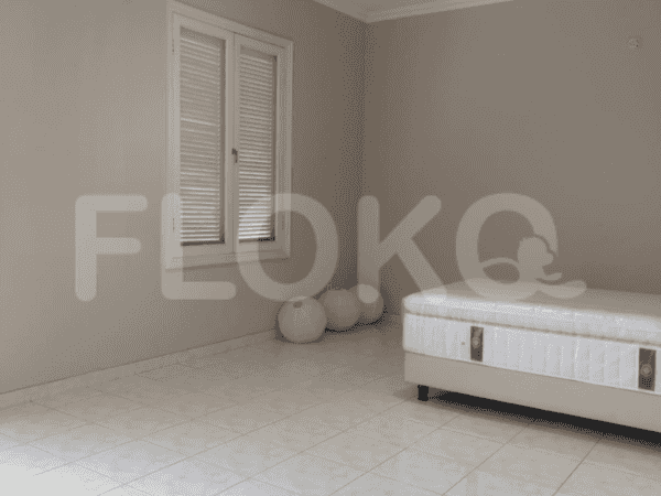 A bedroom featuring a queen-sized bed, large window, and simple decor.