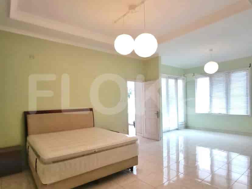 A spacious bedroom with a queen-sized bed, pendant lights, and large windows.