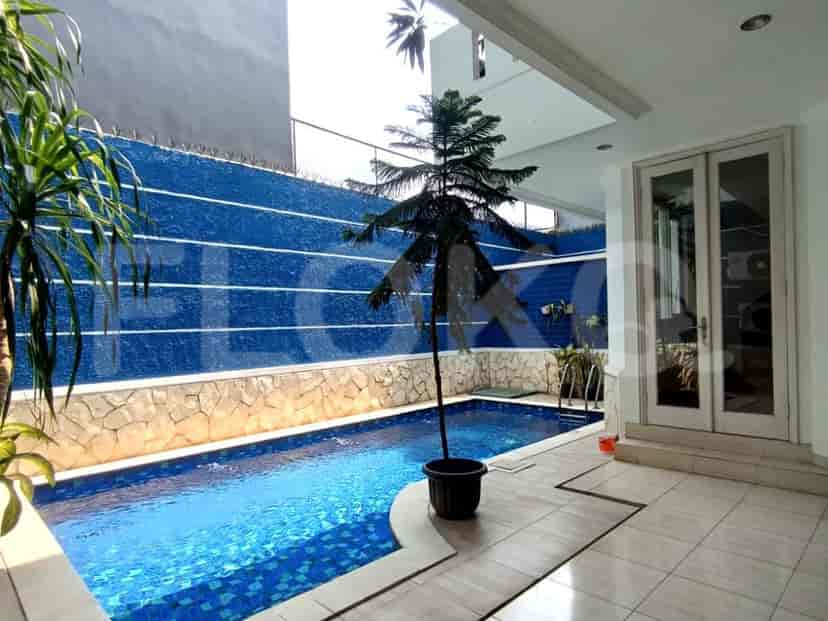 An outdoor swimming pool with a waterfall feature and a patio area.