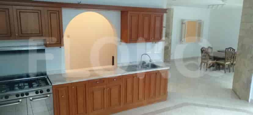 A kitchen with wooden cabinets, marble countertops, and a gas stove.