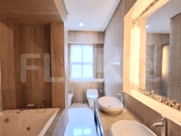 A luxurious bathroom featuring a built-in bathtub, dual vanity with marble countertops, and a large mirror.