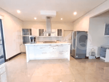A modern kitchen featuring a central island with a cooktop, overhead cabinets, and stainless steel appliances.