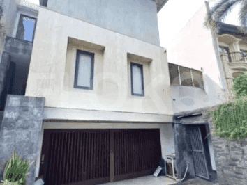 The exterior of a modern villa, featuring a gated entrance, a garage, and a contemporary facade.