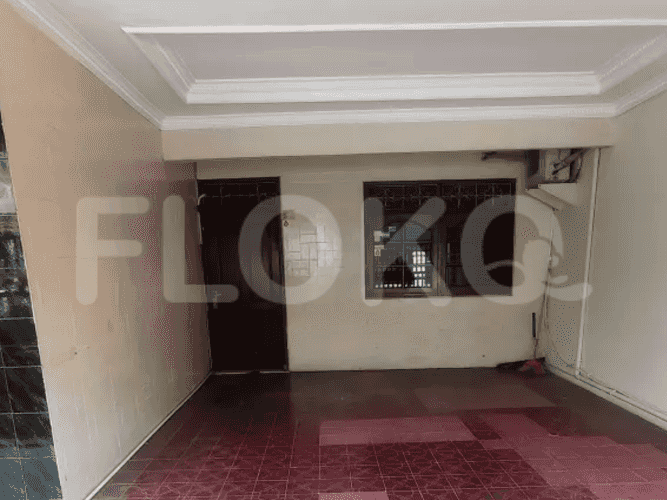 Interior shot of a hallway with tiled floor and dark brown door.
