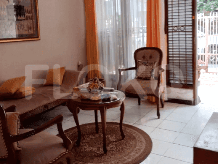 A living room with a sofa, antique chairs, a round coffee table, and a side table.