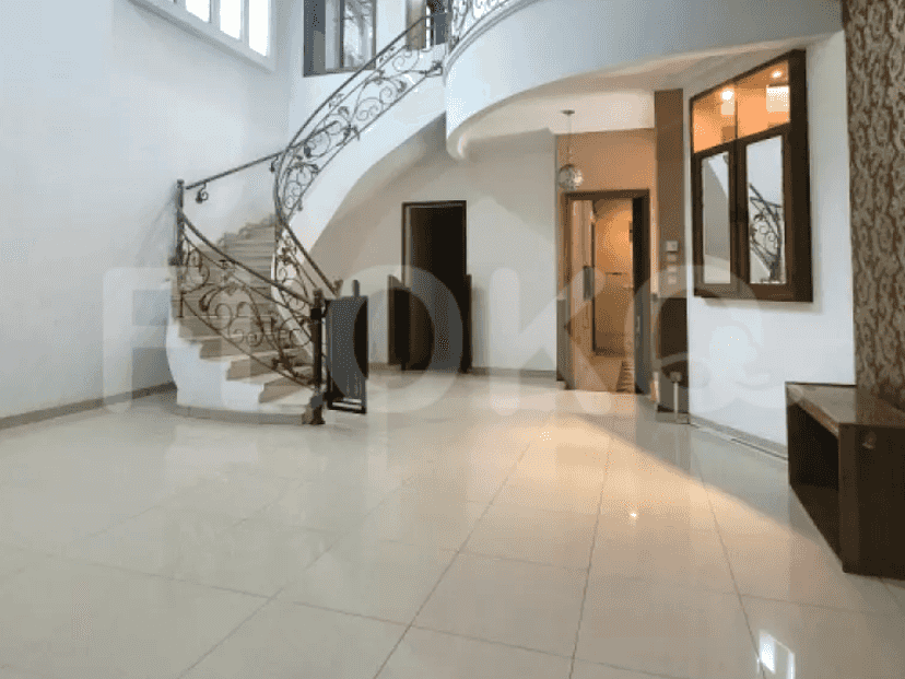 A grand staircase with a curved design, decorative wrought-iron railing, and tiled flooring.
