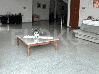 A living room with a marble floor, light fixtures, and a coffee table featuring a central plant arrangement.