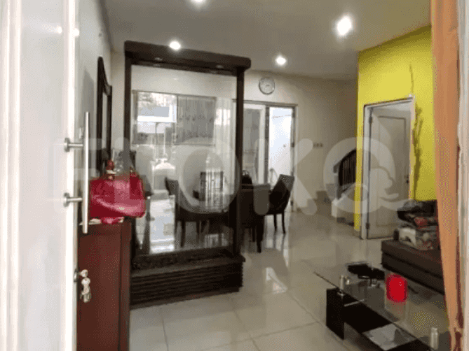 The entry area of the house reveals a dining space, and a glimpse into the living room. Visible details include a wooden partition, dining table, and access to other areas.