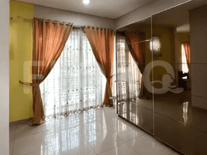 A bedroom showing the glass doors, curtains, wardrobe, and mirrored doors.