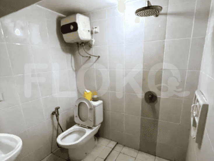 A bathroom featuring a Western-style toilet, shower, and water heater.