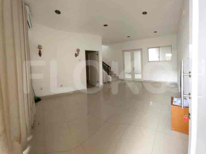 A spacious living room with tiled floors, high ceilings, and an open layout.