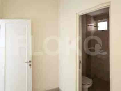 A bathroom with a white door and an open door to the shower area.