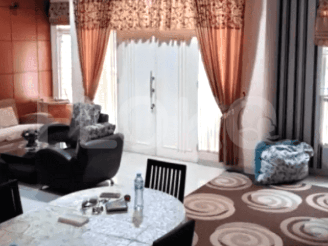 A living room featuring a sofa set, a dining table, and large windows with curtains.