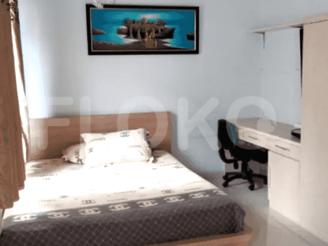 A bedroom featuring a bed, a desk, and a wardrobe.