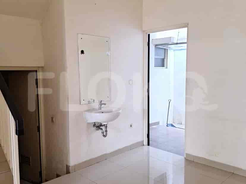 A bathroom with a sink and a mirror, plus the entrance to a small outdoor patio.