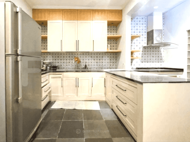 A contemporary kitchen showcasing white cabinets, a central island, and a tiled backsplash.