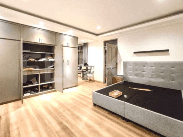 A spacious bedroom featuring a king-size bed, large wardrobes, and light wooden flooring.