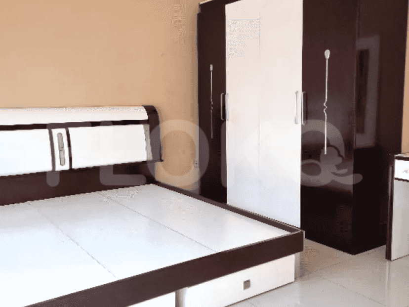 A bedroom featuring a bed with a white and brown headboard, along with a wardrobe.